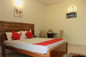 a bedroom with a bed with red pillows and a desk at SAS Apartment in Bangalore +10 photos