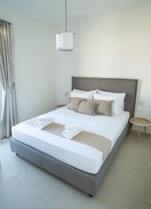 a bedroom with a large bed with white sheets at Villa Artemis 5 - Etheras Properties in Kythira +80 photos