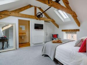 a bedroom with a large bed and a mirror at 4 Bed in Honiton oc-45563 in Payhembury