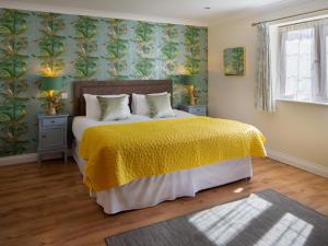 a bedroom with a large bed with a yellow blanket at 3 Bed in Bideford oc-89866 in Westward Ho