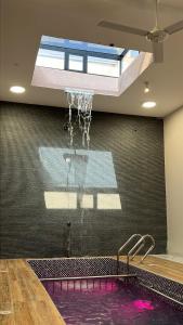 a swimming pool with a sprinkler in a room with at نزل المنظر الليلي in Al Ḩamrāʼ