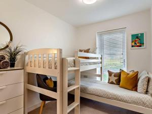 a bedroom with two bunk beds and a couch at 3 Bed in Bideford oc-89018 in Westward Ho