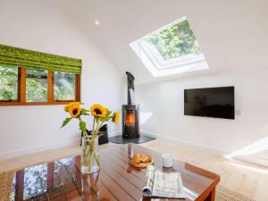 a living room with a vase of flowers on a table at 2 Bed in Kings Nympton oc-87985 in Kings Nympton