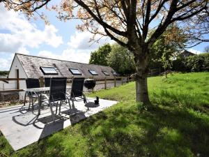 a house with a table and chairs next to a tree at 2 Bed in Kings Nympton oc-87985 in Kings Nympton