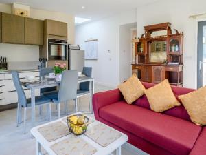 a living room with a red couch and a table at 2 Bed in Crediton oc-78468 in Cheriton Fitzpaine