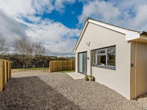 a small white house with a gravel driveway at 1 Bed in Barnstaple oc-91387 in Marwood