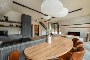 eine Küche und ein Esszimmer mit einem Holztisch und Stühlen in der Unterkunft Sunset A Frames in Bălceşti + 29 Fotos