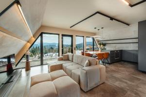 ein Wohnzimmer mit Sofa und Tisch in der Unterkunft Sunset A Frames in Bălceşti