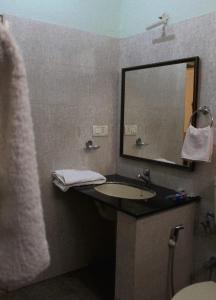 a bathroom with a sink and a mirror at SAS Apartment in Bangalore