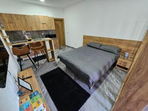 ein Schlafzimmer mit Bett und Schreibtisch sowie eine Küche in der Unterkunft MALM Travnik in Travnik