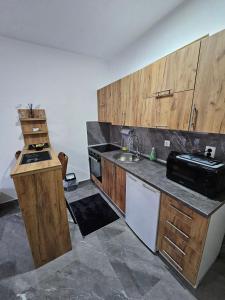eine Küche mit Holzschränken und einer Spüle in der Unterkunft MALM Travnik in Travnik