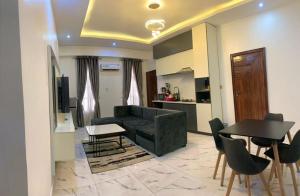 a living room with a couch and a table and chairs at Chris One Bedroom Apartment in Owerri