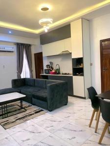 a living room with a couch and a kitchen at Chris One Bedroom Apartment in Owerri