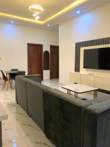 a large room with a flat screen tv and tables at Chris One Bedroom Apartment in Owerri