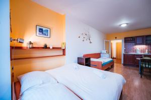 a bedroom with a white bed and a kitchen at Little Mountain Apartment in Ostružná