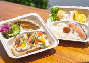 a lunch box with a sandwich and rice and vegetables at Beach Front Seretis in Shimoda
