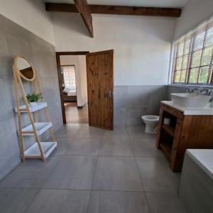 a bathroom with a sink and a toilet at Forest Gate Cabins in Plettenberg Bay +23 photos
