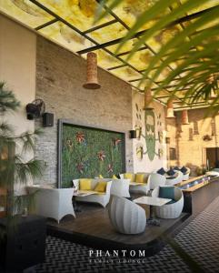 a lobby with white furniture and a large painting on the wall at Hotel Phantom in Gangānagar