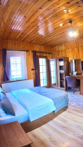 a bedroom with a large bed in a wooden room at Goblec Otel in Uzungöl