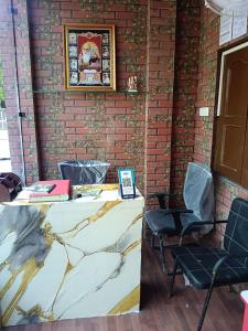 a table and chairs in a room with a brick wall at HOTEL Welcome in Jāmb