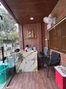 a man sitting at a counter in a room at HOTEL Welcome in Jāmb
