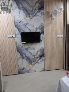 a bathroom with a wall with a tv on it at HOTEL Welcome in Jāmb