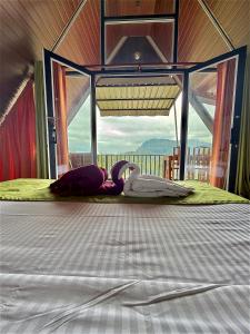 a woman laying on a bed in a tent at Cloudy Hill Cottage in Ella