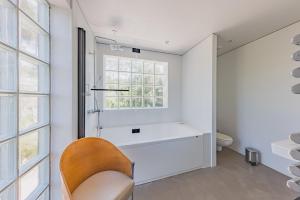 a white bathroom with a chair and a window at Villa Ciel, vue mer in Pyla-sur-Mer +31 photos