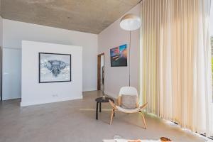 a white room with a chair and a table at Villa Ciel, vue mer in Pyla-sur-Mer