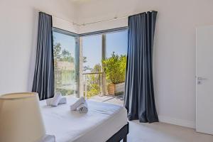 a bedroom with a bed and a large window at Villa Ciel, vue mer in Pyla-sur-Mer