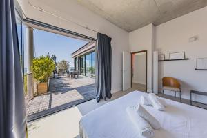 a bedroom with a bed and a large window at Villa Ciel, vue mer in Pyla-sur-Mer