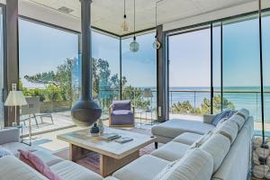 a living room with white furniture and large windows at Villa Ciel, vue mer in Pyla-sur-Mer