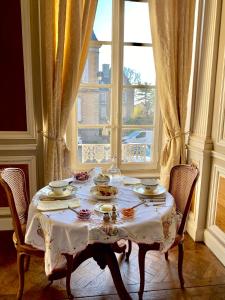 a table in a room with a large window at L'Hotel de Hercé Chambre d'Hote in Mayenne