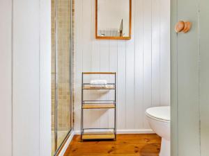a bathroom with a glass shelf next to a toilet at 1 Bed in Paignton oc-93063 in Marldon