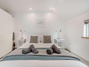 a white bedroom with a large bed with three pillows at 1 Bed in Paignton oc-93061 in Marldon