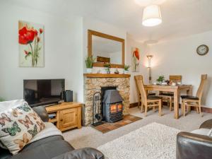 a living room with a fireplace and a dining table at 2 Bed in Bridport oc-58848 in Powerstock