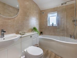 a bathroom with a tub and a toilet and a sink at 3 Bed in Bideford oc-64410 in Northam +3 photos
