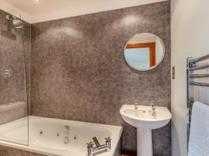 a bathroom with a tub sink and a mirror at 4 Bed in Bideford oc-91814 in Northam +28 photos