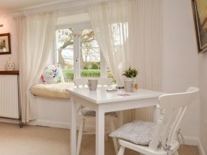 a white table and chairs in a room with a window at 2 Bed in Exeter oc-90455 in Tedburn Saint Mary +13 photos