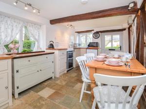 a kitchen with a wooden table and white cabinets at 2 Bed in Exeter oc-90455 in Tedburn Saint Mary