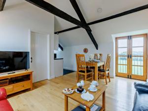 a living room with a tv and a table with chairs at 2 Bed in Bideford oc-housm in Clovelly