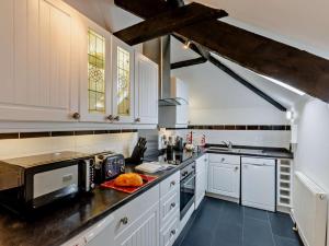 a kitchen with white cabinets and a black counter top at 2 Bed in Bideford oc-housm in Clovelly +11 photos
