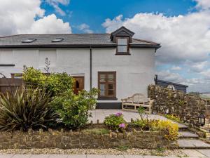 a white house with a bench in front of it at 2 Bed in Bideford oc-housm in Clovelly