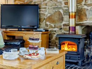 a living room with a table with cupcakes and a fireplace at 4 Bed in Bideford oc-owlbr in Clovelly