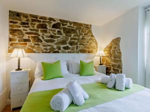a bedroom with a large white bed with green pillows at 4 Bed in Bideford oc-owlbr in Clovelly +22 photos