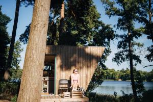a woman standing on the steps of a tiny house at Tiny Houses Klein Ahoi Camp Canow in Wustrow