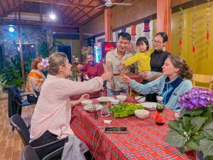 a group of people sitting around a table eating food at The Sam Home in Nguyên Ngoại