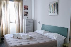 a bedroom with a large bed with white sheets and pillows at GIKLA MAISON in Catania