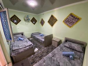 a room with three beds in a room at Guest house Lovely Guest in Bukhara