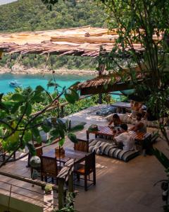 a group of people sitting on a patio near the water at Baan Talay Koh Tao Resort & Yoga in Ko Tao